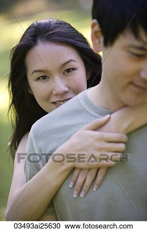 Woman with arms around Man's chest View Large Photo Image Stock Image - Woman with arms around Man's chest. Fotosearch