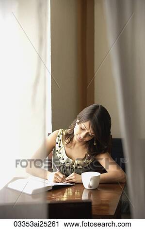 Stock Image - woman with notebook, cup of coffee. Fotosearch