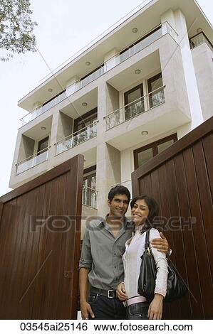 Young couple in front of home View Large Photo Image Stock Photograph - Young couple in front of home. Fotosearch