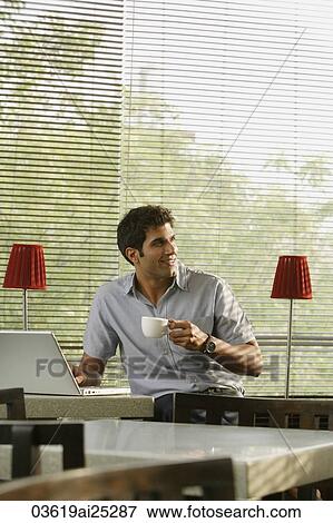 young man at laptop, with coffee View Large Photo Image Stock Photo - young man at laptop, with coffee. Fotosearch