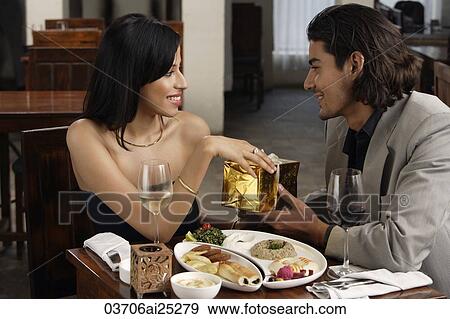 Stock Photo - young man giving gift to young woman. Fotosearch