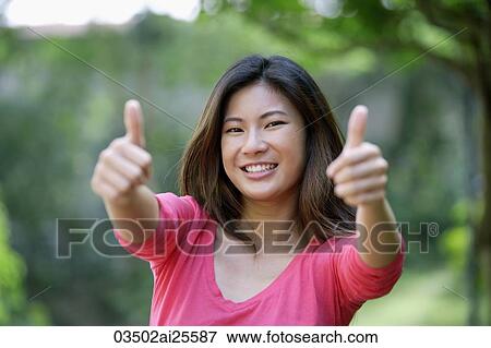 Young woman making "thumb's up" sign View Large Photo Image Stock Photo - Young woman making "thumb's up" sign. Fotosearch