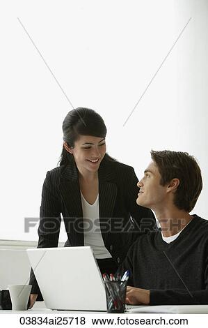 Stock Photo - Business colleagues working at laptop. Fotosearch
