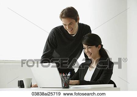 Stock Photo - Business colleagues working at laptop. Fotosearch