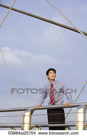 Businessman leaning on bridge View Large Photo Image Picture - Businessman leaning on bridge. Fotosearch
