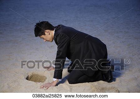 Businessman looking into hole in sand View Large Photo Image Stock Photography - Businessman looking into hole in sand. Fotosearch