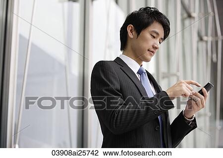 Businessman sending message on mobile device View Large Photo Image Stock Image - Businessman sending message on mobile device. Fotosearch