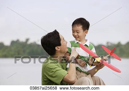 Father and son playing with toy airplane View Large Photo Image Stock Photo - Father and son playing with toy airplane. Fotosearch