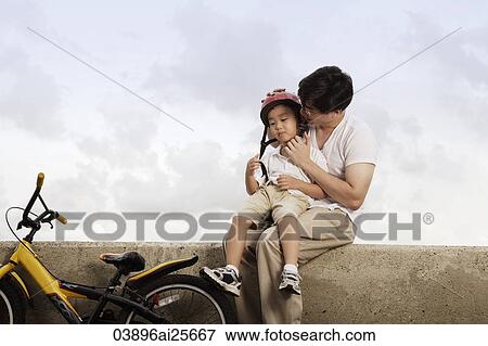 Father hugging son after bike ride View Large Photo Image Stock Photo - Father hugging son after bike ride. Fotosearch