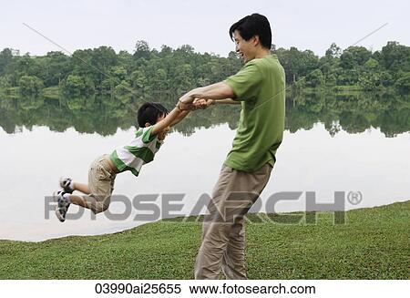 Father swinging son by arms View Large Photo Image Stock Photography - Father swinging son by arms. Fotosearch