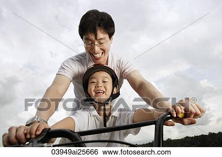 Stock Photograph - Father teaching son how to ride bike. Fotosearch