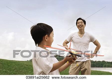 Father watching son play with toy airplane View Large Photo Image Stock Image - Father watching son play with toy airplane. Fotosearch