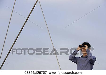 man looking through binoculars View Large Photo Image Stock Photo - man looking through binoculars. Fotosearch