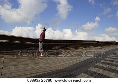 Stock Photograph - Man looking up to sky. Fotosearch