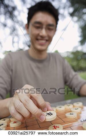 Man making move in Chinese chess game View Large Photo Image Stock Photo - Man making move in Chinese chess game. Fotosearch