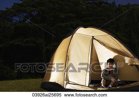 Stock Photography - Man reading inside tent. Fotosearch