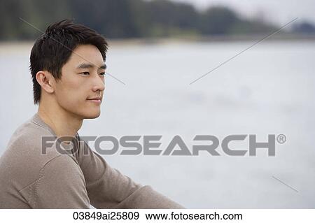 Stock Photo - Profile of man sitting next to bay. Fotosearch