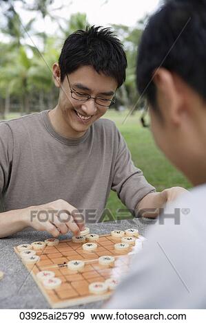 Two men playing Chinese chess in park View Large Photo Image Stock Photo - Two men playing Chinese chess in park. Fotosearch