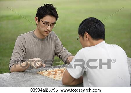 Stock Photography - Two men playing Chinese chess in park. Fotosearch