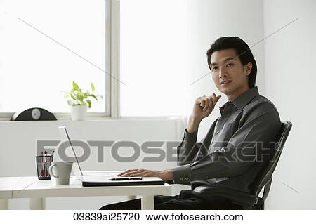 Stock Image - Young businessman at computer. Fotosearch