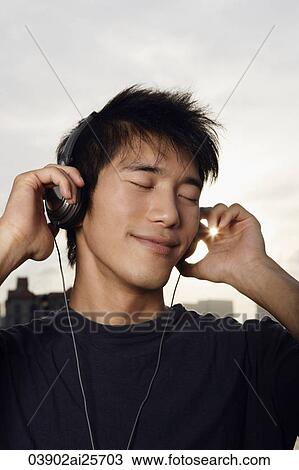 Young man listening to music View Large Photo Image Stock Image - Young man listening to music. Fotosearch