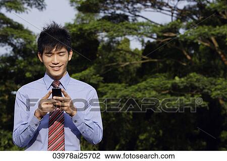 Young man reading text messages View Large Photo Image Stock Image - Young man reading text messages. Fotosearch