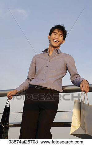 Stock Photo - young man with shopping bags. Fotosearch