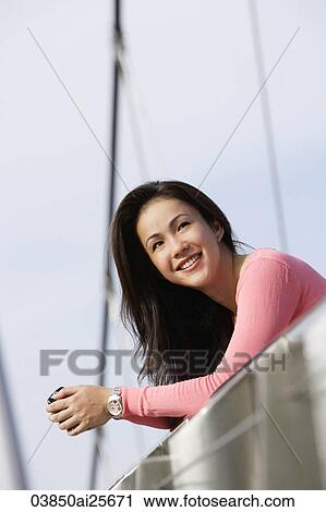 Young woman leaning over bridge View Large Photo Image Stock Image - Young woman leaning over bridge. Fotosearch