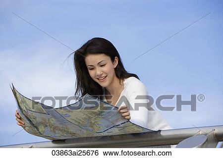 Stock Photograph - Young woman reading map. Fotosearch