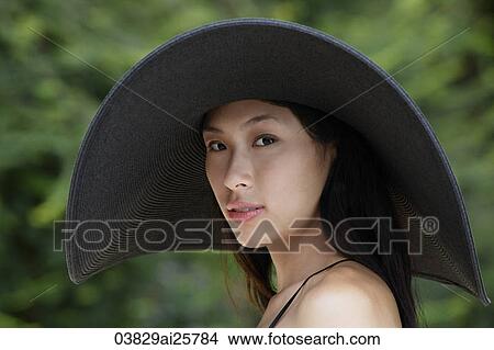 Picture - Young woman wearing big black hat. Fotosearch