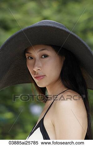 Stock Photography - Young woman wearing big black hat. Fotosearch