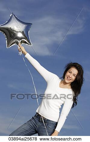 Young woman with silver star-shaped balloon View Large Photo Image Stock Photo - Young woman with silver star-shaped balloon. Fotosearch