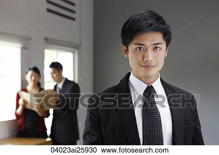 Stock Image - Businessman in foreground, colleagues in background. Fotosearch