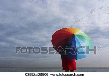 Legs of young woman underneath big umbrella View Large Photo Image Stock Photograph - Legs of young woman underneath big umbrella. Fotosearch