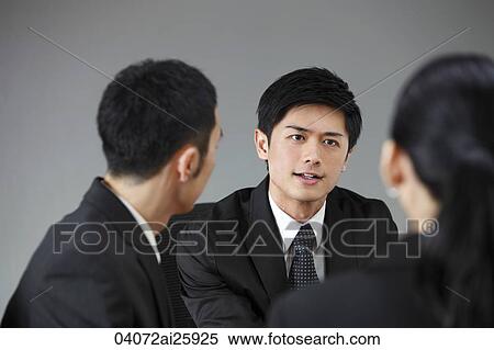 Stock Photography - Three colleagues having a meeting. Fotosearch