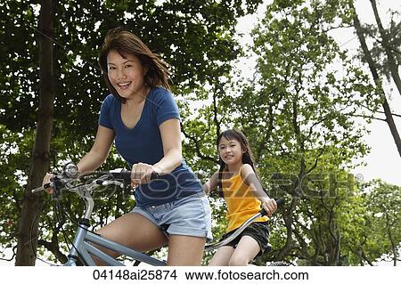 woman and young girl riding tandem bike View Large Photo Image Picture - woman and young girl riding tandem bike. Fotosearch