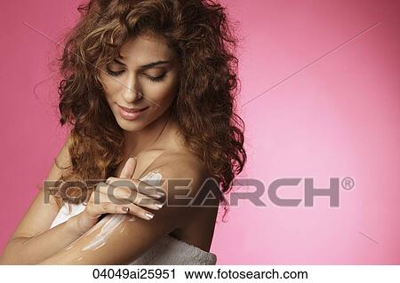 Stock Image - woman applying skin lotion. Fotosearch