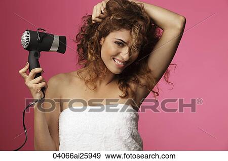 Woman blow drying her hair View Large Photo Image Stock Photo - Woman blow drying her hair. Fotosearch
