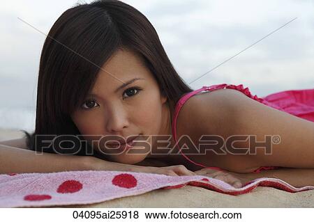 Woman lying on towel on sand View Large Photo Image Stock Photo - Woman lying on towel on sand. Fotosearch