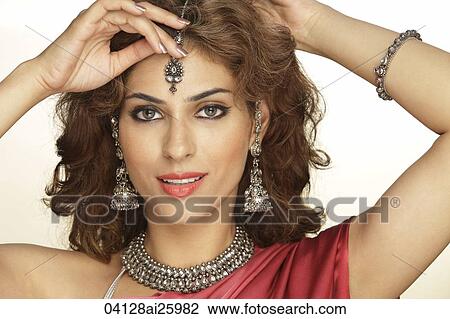 Stock Image - woman wearing sari and decorated with traditional jewelry. Fotosearch