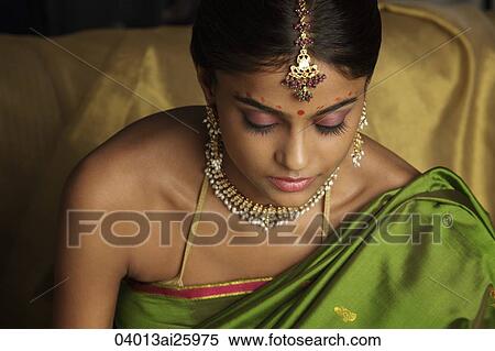Stock Photography - woman wearing sari and decorated with traditional jewelry and bindi. Fotosearch