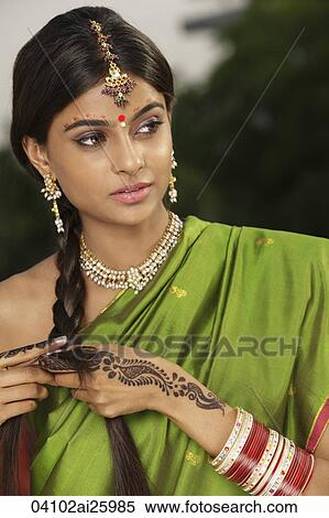 Stock Photography - woman wearing sari and decorated with henna tattoo, traditional jewelry and bindi. Fotosearch
