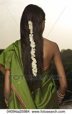 Picture - woman wearing sari with strand of jasmine blossom in her hair. Fotosearch