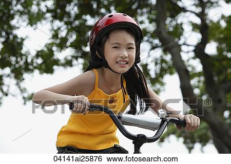 Young girl riding bike View Large Photo Image Stock Photograph - Young girl riding bike. Fotosearch