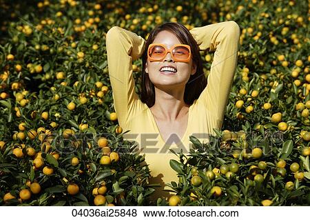Young woman among orange plants View Large Photo Image Stock Photo - Young woman among orange plants. Fotosearch