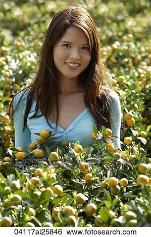 Young woman among orange plants View Large Photo Image Stock Photograph - Young woman among orange plants. Fotosearch
