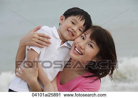 Stock Image - young woman and boy cheek to cheek. Fotosearch