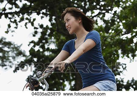 Young woman riding bike View Large Photo Image Stock Photo - Young woman riding bike. Fotosearch
