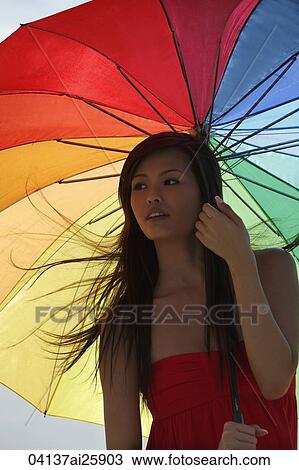 Young woman standing under bright umbrella View Large Photo Image Stock Image - Young woman standing under bright umbrella. Fotosearch