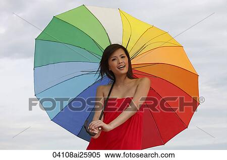 Stock Photography - Young woman standing under bright umbrella. Fotosearch